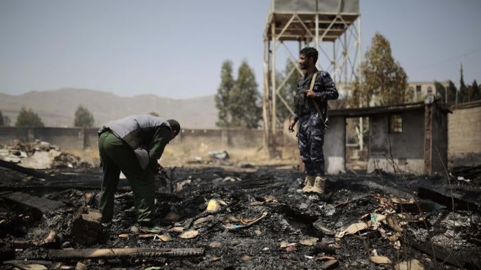Yemeni police inspect a site of Saudi-led airstrikes that hit two houses in Sanaa, Yemen, March 26, 2022. 