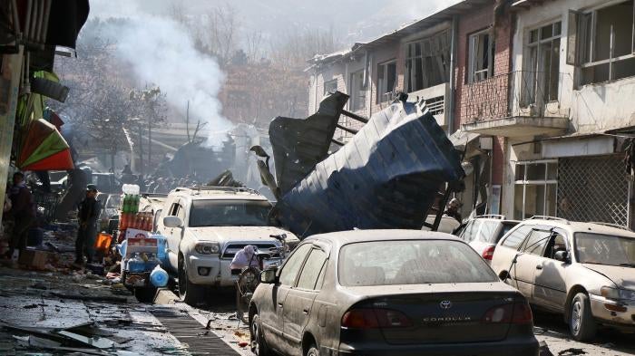 Afghan security officials inspect the site of a Taliban suicide bombing in Kabul.