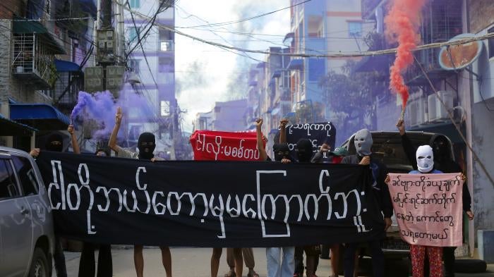 Protesters hold a banner reading “We will never be frightened,” in Yangon, Myanmar