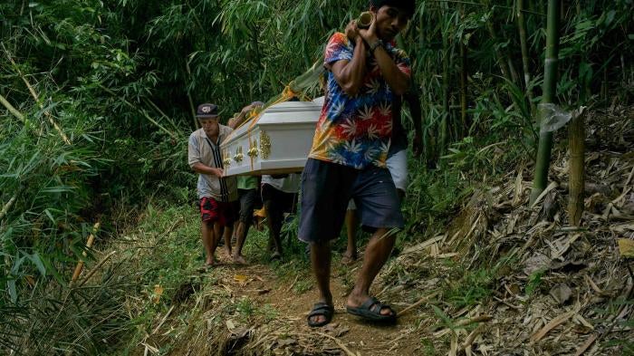 Family and members of the Indigenous Dumagat tribe carry the coffins of Puroy and Randy Dela Cruz to be buried in Rizal province