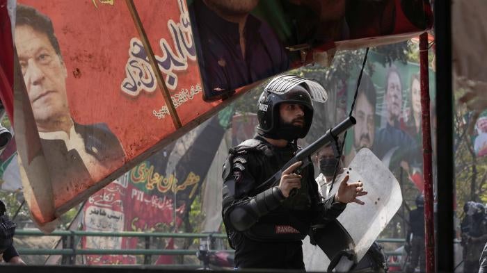 A riot police officer looks on after firing tear gas to disperse supporters of former Prime Minister Imran Khan during clashes in Lahore, Pakistan, March 15, 2023.