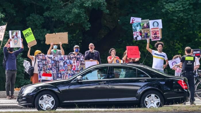 Protesters hold banners and chant slogans during Egyptian President Abdel Fattah al-Sisi’s official visit to Germany on July 18, 2022, in Berlin.