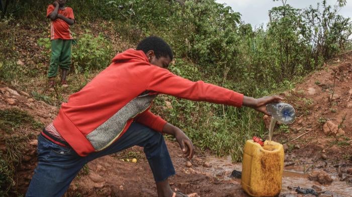 A 16-year-old boy collects water from a spring near Lega Dembi gold mine in the Oromia region of Ethiopia. @2020 Tom Gardner 