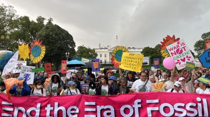 On Earth Day, marchers at the Whit House hold  a banner reading, “End the Era of Fossil Fuels” Washington, DC.