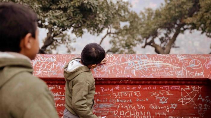 Children write in chalk on the walls of a Saraswati temple on the festival of Saraswati Puja
