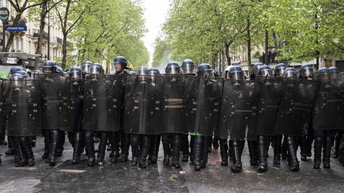 Riot police from the Gendarmerie Mobile advance in line as thousands of demonstrators take part in the traditional May Day demonstration, Paris, France.