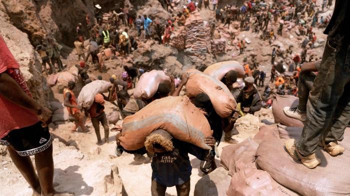  Artisanal miners carry sacks of ore at a mine near Kolwezi, Democratic Republic of Congo, October 12, 2022.