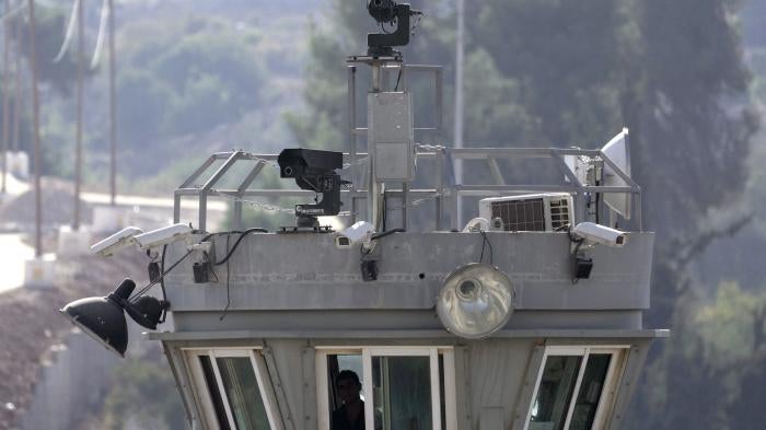 Two guns sit atop a guard tower along with surveillance cameras pointed at the Aroub refugee camp in the West Bank, October 6, 2022. 
