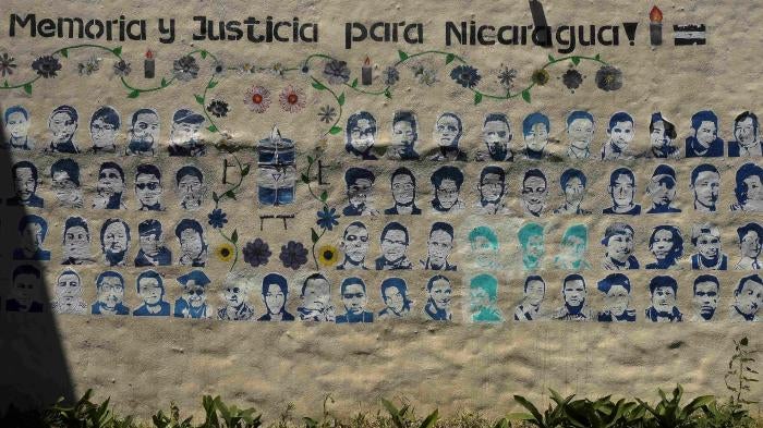 A mural showing images of Nicaraguans killed during the 2018 social security reform protests under the words “memory and justice for Nicaragua”  adorns a wall at the Nicaragua Nunca Más human rights organization in San Jose, Costa Rica, February 20, 2023.