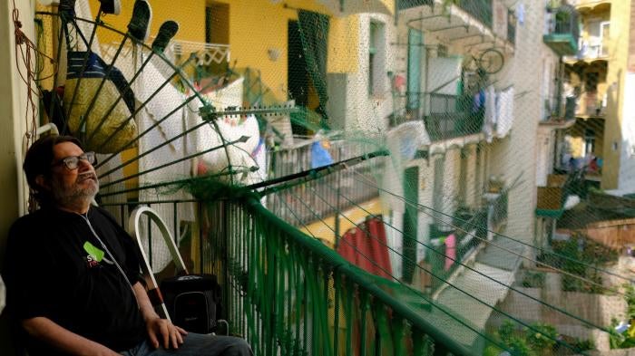 Fernando Uceta, who has COPD, uses a portable oxygen concentrator to breathe as he sits on the balcony of his home during the summer heatwave, in Barcelona's Raval neighbourhood, Spain, June 27, 2023.