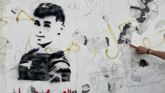 A graffito of Mohammed al-Sleem on the wall of a school he ran past while fleeing from Israeli soldiers who fatally shot him in the back, May 5, 2023. Witnesses said automatic gunfire left 10 bullet impacts in the wall, near Azzun, in the West Bank. 
