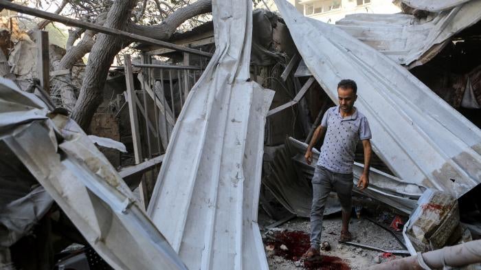 A man walks through the rubble of Israeli strikes in Gaza City, October 15, 2023. 