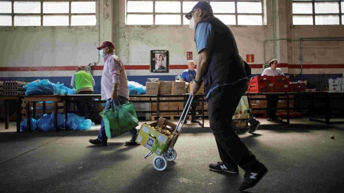 Volunteers attend to people at the Food Bank of Lugo, May 2, 2023, in Lugo, Galicia, Spain.