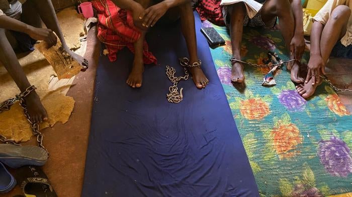 Four men sit chained in a room at the Coptic Church Mamboleo, in Kisumu city, western Kenya, where over 60 men, women, and children with real or perceived mental health conditions are detained. Staff at the church say residents are naked or partially clothed so that they do not run away or escape. 