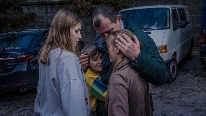 Denys Zaporozhchenko reunites with his children in Kyiv, Ukraine, March 22, 2023.  