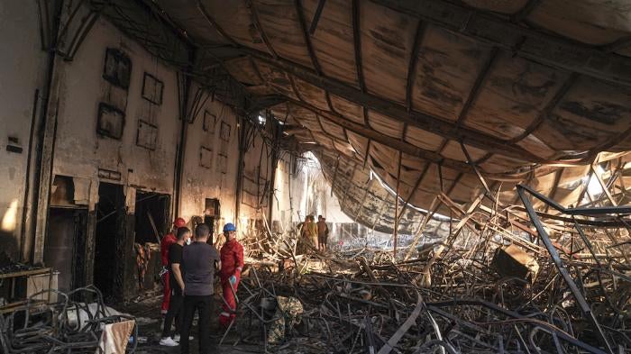 Members of the search team work at a burned down wedding hall after a fatal fire engulfed the hall during a wedding celebration, September 27, 2023. 