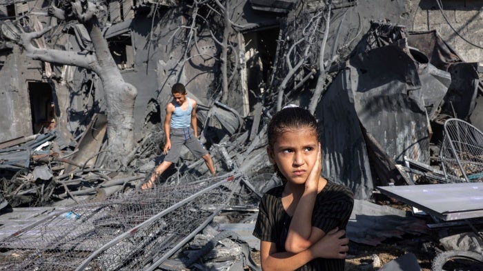 A girl stands by the rubble outside a building hit by Israeli bombardment in Rafah in the southern Gaza Strip on October 31, 2023. 