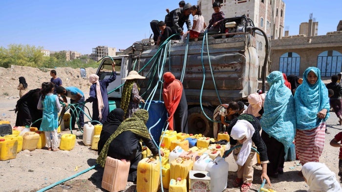 A group of women and children get water from a water truck in the Osaifera area, Taizz, March 7, 2023. 