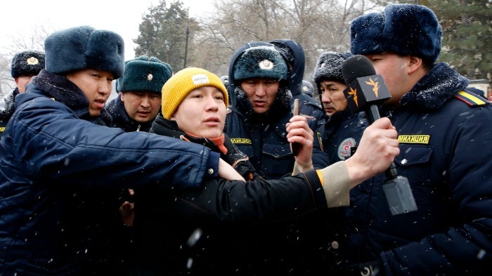 Police officers detain a journalist covering a protest near the government building in Bishkek, Kyrgyzstan, January 10, 2023. Protesters demanded the release of detained members of the so-called Kempir-Abad reservoir support committee.