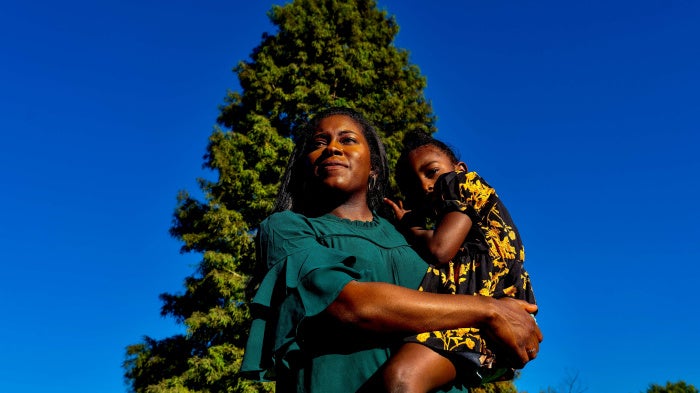 A woman poses for a photo holding her son