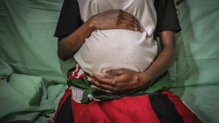 A 19-year-old mother is seen holding her baby bump in Nairobi, Kenya, July 7, 2020. 