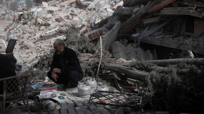 A man beside the rubble of a building in Antakya, southern Türkiye, on March 6, 2023, one month after the devastating earthquakes in which over 50,000 people died and hundreds of thousands were injured and displaced.