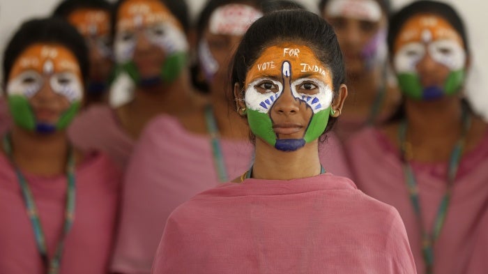 School teachers with the colors of the Indian national flag painted on their faces participate in an event to raise awareness among people to vote in the upcoming general elections