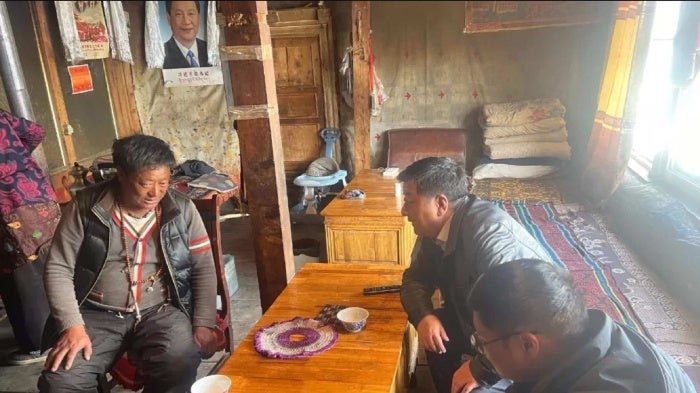 貢覺縣中共黨委副書記到居民家中訪問，勸說他們同意整村搬遷，西藏自治區三岩（Sa-ngen）地區，2024年3月。