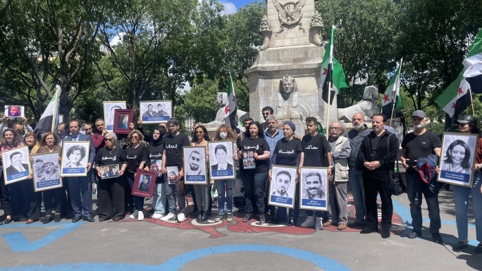 Victims’ and families’ associations gathered next to the Paris Criminal Court on May 21, 2024, holding photos of relatives who have been detained or disappeared in Syria