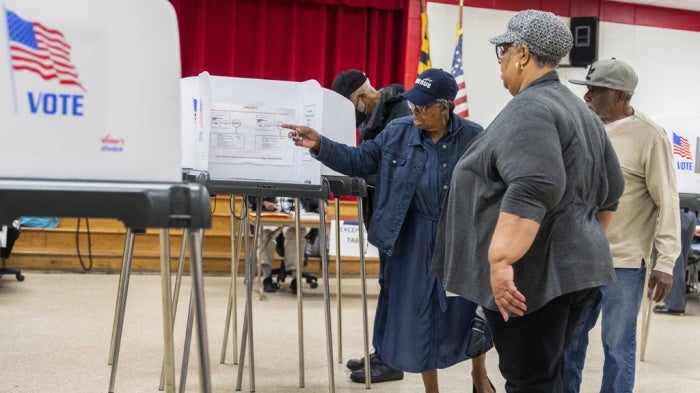 Election workers help voters on the state's primary election day at Lewisdale Elementary School in Chillum, Maryland, May 14, 2024.