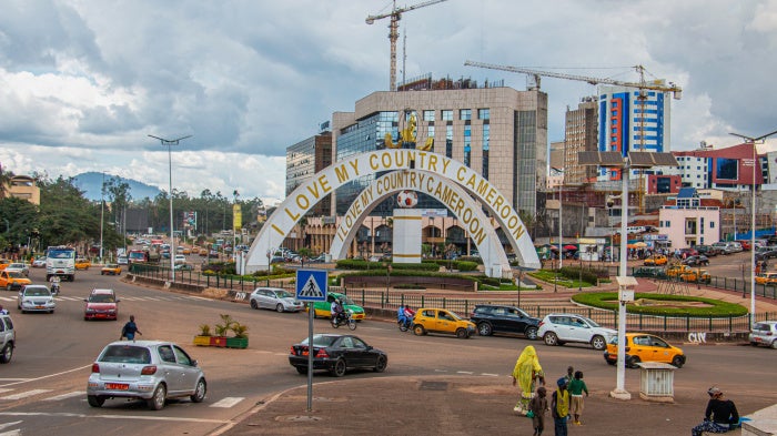Cars drive through an intersection near a monument in Yaoundé, Cameroon, September12, 2025. 