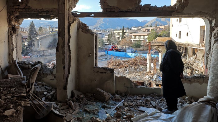 A woman looks out from her destroyed apartment in the Shahrak-e Gharb neighborhood of Tehran, Iran, March 21, 2026. 
