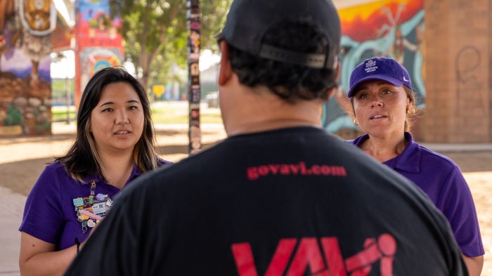 Two crisis response team members speak to a man 