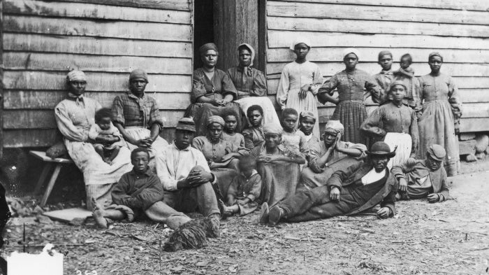 Formerly enslaved people sit at Foller's House in Cumberland Landing, Virginia, US, circa 1850.