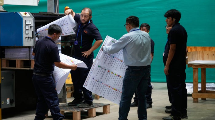 Electoral workers inspects a color test of newly printed ballots ahead of the presidential election, during a media presentation in Lima, Peru, Tuesday, March 10, 2026.