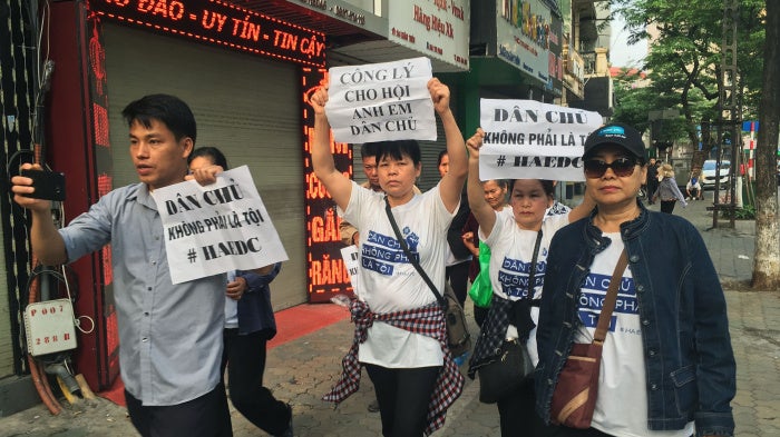  Protesters, including Can Thi Theu and Trinh Ba Tu, display placards as they march towards a courthouse during the trial of the prominent lawyer Nguyen Van Dai and five other activists in Hanoi, Vietnam, on April 5, 2018.