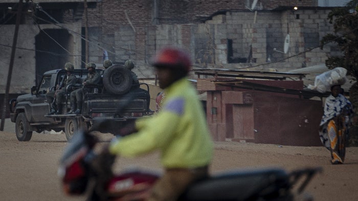 A car of armed soldiers patrols a street