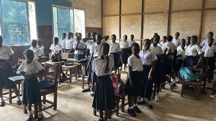 Students standing at their desks in a classroom