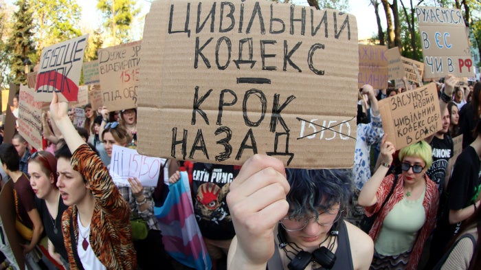 A placard reads "Civil Code Is Step Back" during a peaceful protest to urge MPs to refine the draft of the new Civil Code taking into account amendments proposed by human rights activists, in Mariinsky Park, Kyiv, Ukraine, May 5, 2026. 