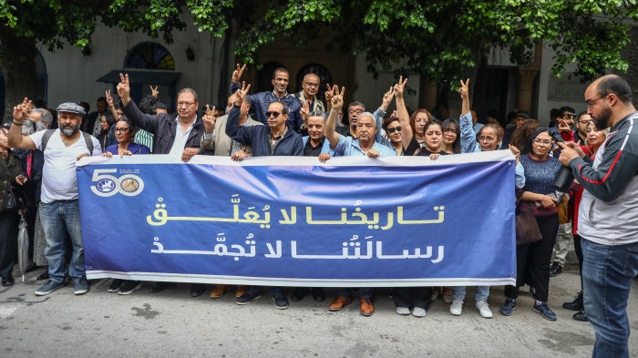 Demonstrators display a banner in Arabic reading, ''Our history will not be halted, and our message does not freeze,'' during a rally after Tunisian authorities suspended the Tunisian League for Human Rights, outside the court of First Instance in Tunis, May 6, 2026. 