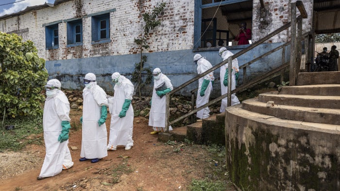 Health workers wearing protective equipment walk outside the General Referral Hospital during the Ebola outbreak response in Mongbwalu, Democratic Republic of Congo, May 21, 2026.