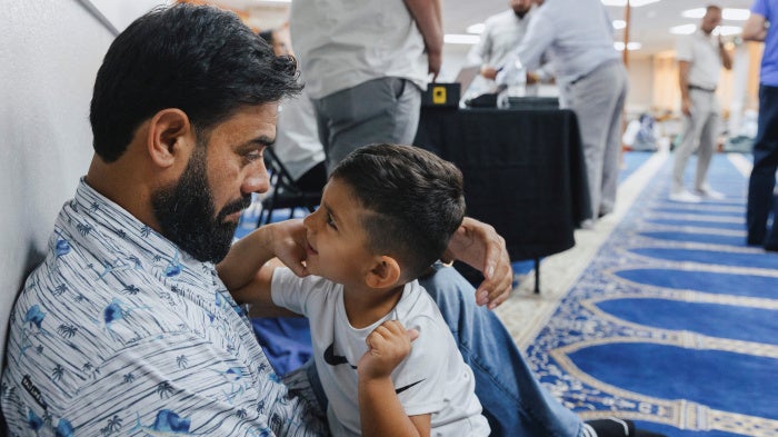 Naseer Ahmad Paktiawal holds Abubakar Paktiawal, son of his brother Mohammad Nazeer Paktiawal, who died in ICE custody, at the Abu Hanifa Mosque in Richardson, Texas, U.S. June 4, 2026.