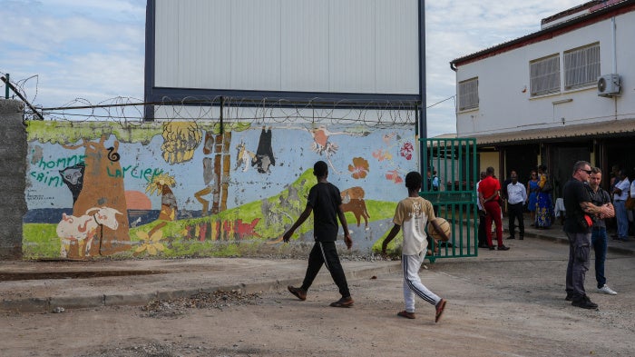 Children walk past modular classrooms built after Cyclone Chido, at the nursery and elementary school of Majicavo-Lamir village on the French overseas territory of Mayotte, on August 18, 2025.