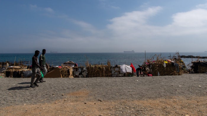 Two of the migrants and asylum seekers who swan to Ceuta in July 2026, walk on the Trampolín beach, August 2026.