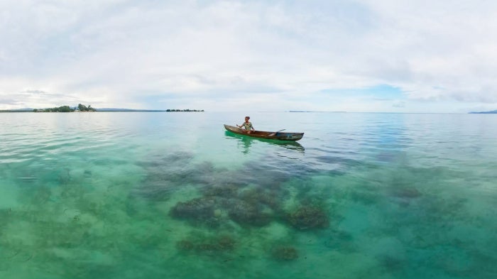 A girl in her fishing boat off the coast of Malaita Province, Solomon Islands. 
