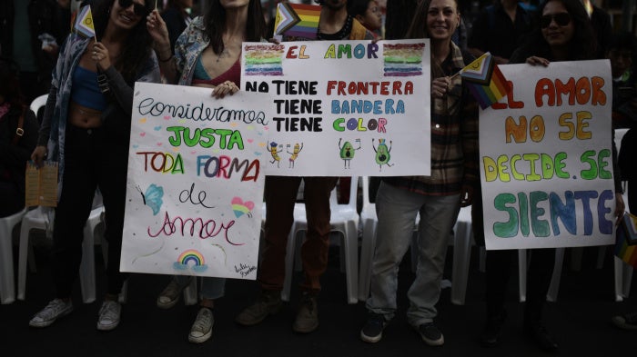 people hold placards at a pride march