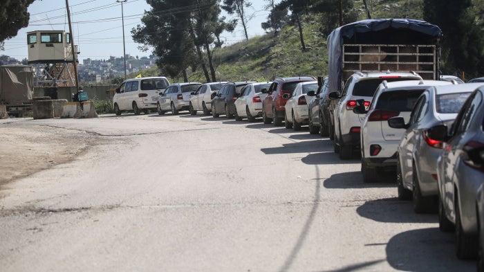 Palestinians wait to cross at the Israeli Awarta military checkpoint on March 23, 2025, south of Nablus in the West Bank.