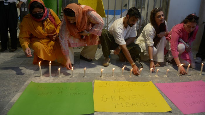 People light candles in memory of the newborn victims outside the Pakistan Institute of Medical Sciences, in Islamabad, Pakistan, August 27, 2026. 