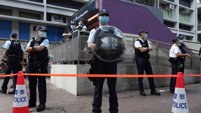 Police officers stand guard outside the Prince Edward subway station