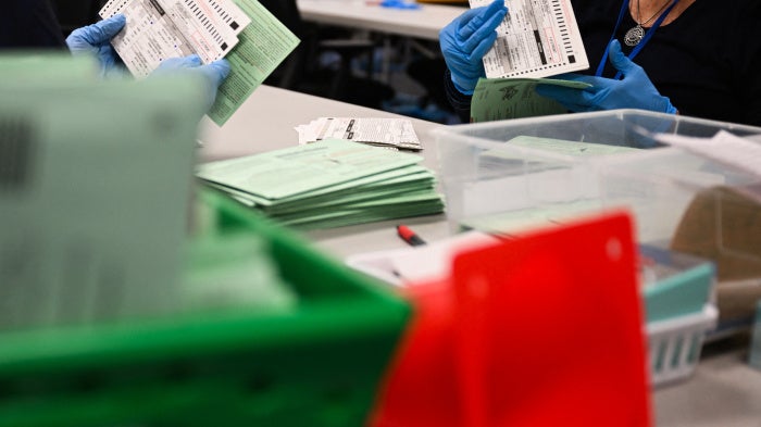 US election workers open and inspect mail-in ballot envelopes during processing inside the Maricopa County Tabulation and Election Center (MCTEC) on Election Day, November 5, 2024, in Phoenix, Arizona.